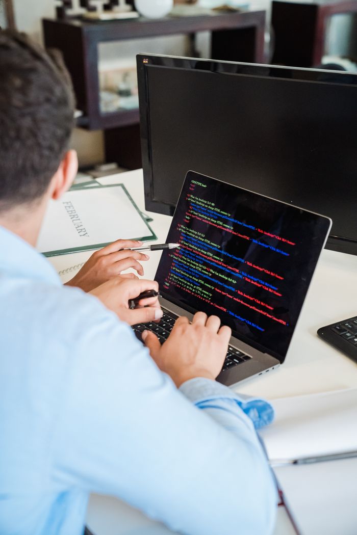 Mastering the First Impression: Your intriguing post title goes here An office worker intensely typing code on a laptop, showcasing programming skills.