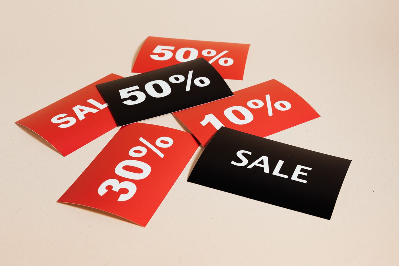 The Art of Drawing Readers In: Your attractive post title goes here Red and black sale tags showing various discount percentages on a beige background.